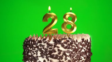 Çikolatalı doğum günü pastasında mum yakmak yeşil krom anahtar arka planda 28 numaralı altın mumla. 28 yıldır doğum günü pastasını kutluyoruz. Boşluğu kopyala