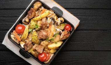 Restorandaki bir masada patates, mantar ve sebzeli fırında domuz kızartma tavası, yukarıdan görüş. Boşluğu kopyala