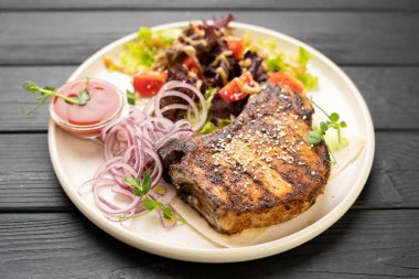 Sebzeli ızgara domuz bifteği ve masada soğan turşusu. Üst görünüm