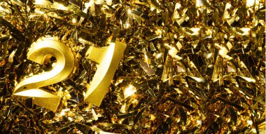 Doğum gününü kutlamak için 21 numaralı altın mum, süslü püslü arka planda. Yirmi birinci yaş günü. Doğum günü kutlaması kavramı. Boşluğu kopyala