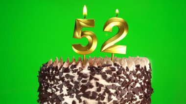 Doğum günü pastasında 52 numaralı mumları krom anahtarla yakmak. Elli ikinci doğum günü. Doğum günü kutlaması kavramı. Yakın plan.