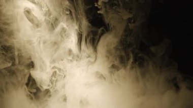 Siyah arka planda beyaz sigara dumanı uçuşuyor. Yakın plan.