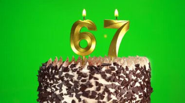 Doğum günü pastasında krom anahtar arka planında 67 numaralı mumları yakmak. Altmış yedinci doğum günü. Doğum günü kutlaması kavramı