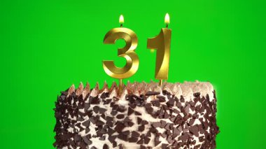 Çikolatalı doğum günü pastasında mum yakmak yeşil krom anahtar arka planda otuzbir numaralı altın mumlarla. 31 yıldır doğum günü pastasını kutluyoruz. Boşluğu kopyala