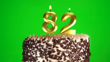 Doğum günü pastasında 82 numaralı mumları krom anahtarla yakmak. Seksen ikinci yaş günü. Doğum günü kutlaması kavramı