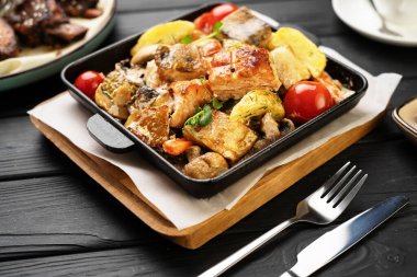 Masada ızgara somon parçaları ve sebzeli tava, balıktan yükselen buhar, restoranda deniz mahsulleri yemeği konsepti, yakın görüş.