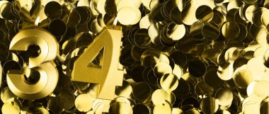 Altın numara 34 mum, parlak sarı konfeti arka planında. Otuz dördüncü yaş günü, yıldönümü ya da kutlama için şölen arkaplanı. Metin için yeri olan parlak tebrik kartı.
