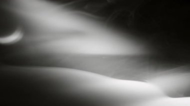 Soyut arkaplan dumanı siyah arkaplanda yavaşça kıvrılır