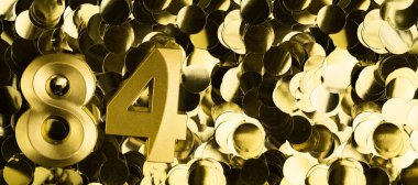 Parlak sarı konfeti arka planında 84 mum. Seksen dördüncü yaş günü, yıldönümü ya da kutlama için şenlik arkaplanı. Metin için yeri olan parlak tebrik kartı.