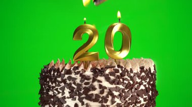 Çikolatalı doğum günü pastasında mum yakmak yeşil renkli anahtar arka planda yirmi numaralı altın mumlarla. 20 yıldır doğum günü pastasını kutluyoruz. Boşluğu kopyala