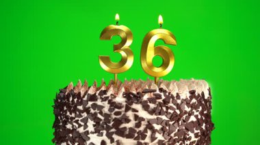Çikolatalı doğum günü pastasında mum yakmak yeşil krom anahtar arka planda 36 numaralı altın mumla. 36 yıldır doğum günü pastasını kutluyoruz. Boşluğu kopyala