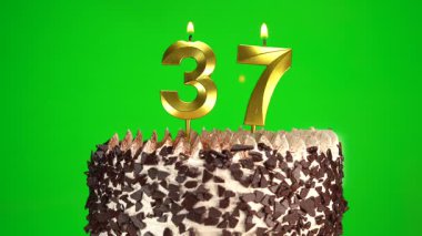 Çikolatalı doğum günü pastasında mum yakmak yeşil krom anahtar arka planda 37 numaralı altın mumla. 37 yıldır doğum günü pastasını kutluyoruz. Boşluğu kopyala