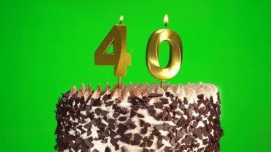 Çikolatalı doğum günü pastasında mum yakmak yeşil krom anahtar arka planda 40 numaralı altın mumla. 40 yıldır doğum günü pastasını kutluyoruz. Boşluğu kopyala