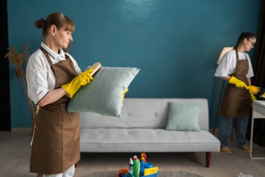 Temizlik hizmeti konsepti. Daireyi temizleyen iki kadın işçi takımı. Boşluğu kopyala