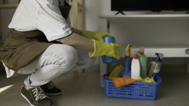 Temizlik sepetinden çöp torbalarını almak için eğilen hademe kadın temizlik, ev temizliği, profesyonel hizmetli personelinin temizlik süreci..