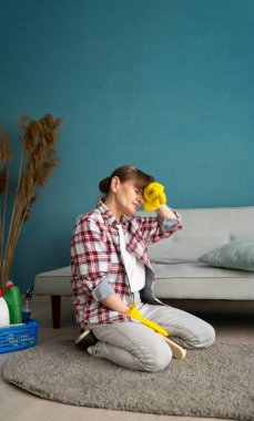 Üzgün ev hanımı ev işi yüzünden yorgun başını halının üzerinde tutarak oturuyor. 60 'lı yaşlardaki bayan ev işinden yorgun düşüyor. Boşluğu kopyala