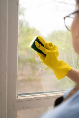 Temizlik yapan kadın sünger dezenfektan kullanıyor. Temizlikçi. Yakın plan.