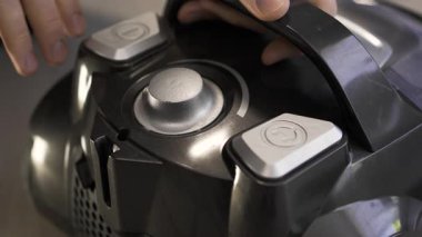 Elektrik süpürgesinin başlatma düğmesine bas. Ev temizliği kavramı