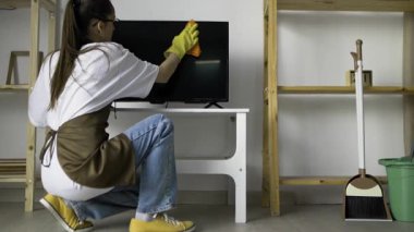 Kadın hademe televizyondan toz temizliyor. Apartman temizliği. Boşluğu kopyala