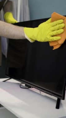 Önlüklü sakallı adam ve televizyon ekranını temizleyen sarı eldivenli adam. Oda servisi ve temizlik konsepti