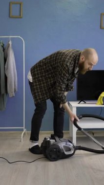 Yerleri süpüren adam. Temizlik ve ev işleri konsepti. Dikey video