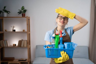 Kötü hafıza konsepti. Kadın temizlikçi ya da temizlikçi şaşırmış bir ifadeyle elinde temizlik ürünleri tutarken hata ve hata olduğunu düşünüyor. Boşluğu kopyala