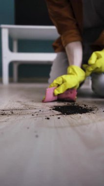 Temizlik servisi. Ev temizliği konsepti. Paçavra mendilli bir adam. Toprağın temizlenmesi. Dikey video