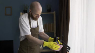 Erkek temizlikçi, masa lambasının tozunu alıyor. Ev işi ve ev temizliği konsepti. Boşluğu kopyala