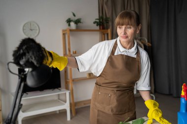Ev Temizliği İçin Yumuşak Fırça Kullanan Kadın Temizlikçi Masa Lambası. Ev işi, temizlik ve temizlik konsepti