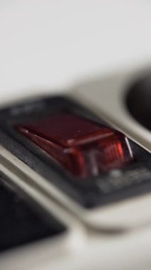 Güç şeridindeki erkek eli açma kırmızı düğmesi. Elektrik tasarrufu. Elektrik düğmesini açıyorum. Yakın plan.