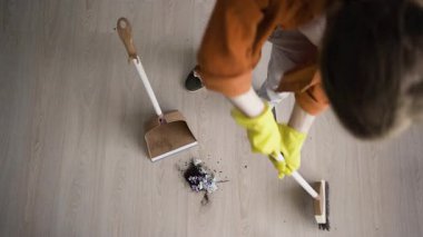 Hafta sonları faraş ve süpürge temizleme eviyle yerleri süpüren bir adamın en iyi görüntüsü. Oda temizliği ve temizlik konsepti