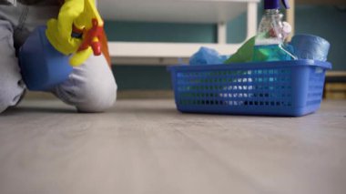 Lastik eldivenli bir adamın yeri fırçayla temizlerken deterjan spreyi kullanmasını sağla. Oda servisi, ev işi, düzenli ve temizlik konsepti