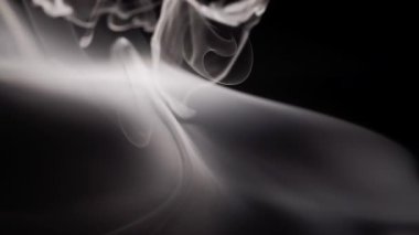 Kalın beyaz duman, karanlık bir arkaplanda kıvrılarak büyüleyici ve soyut bir görsel görüntü yaratır. Esrarengiz atmosfer.
