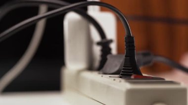 Priz prizinde elektrik prizi var. Man 'in yakın plan fişi çekiliyor. Boşluğu kopyala
