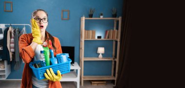 Şok olmuş kadın temizlikçi, elinde eldivenlerle elinde sepetle beklenmedik haberlere duygusal tepki göstererek temizlik yaptıktan sonra şaşırıyor ve güvensizliğini dile getiriyor. Pankart. Boşluğu kopyala