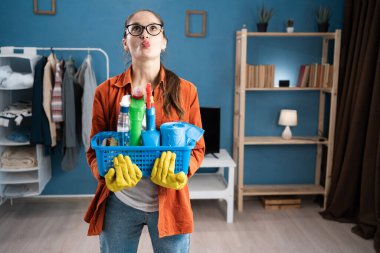 Balık gibi dudaklarını büzen ve elinde sepet tutarak şüpheyi ifade eden bir kadın. İroni ya da temizlik anındaki daha büyük güce yönelik bir soru. Boşluğu kopyala