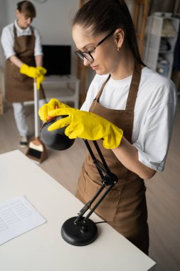 Oturma odasında çalışan temizlikçi kadın işçiler. Temizlikçiler ev işlerini ya da ev işlerini severler. Boşluğu kopyala