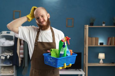 Düşünceli bir kavram. Önlük taşıyan sakallı bir adam temizlik malzemeleriyle dolu bir sepet tutuyor ve şüpheyle ilgili soru soruyor. Boşluğu kopyala