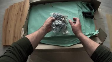 Mutfak dolabı parçalarını açan el kamerası görüntüleri, menteşeler ve videler de dahil, bir kutudan. Tahta tahtalar ve tesisatlar DIY montajı için ayarlandı. mobilya kurulumu.