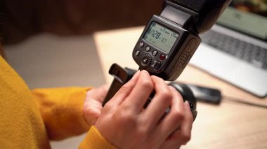 Fotoğrafçı ellerinin kameradaki flaş kontrollerini kapatarak elle ayarlama, ışıklandırma, fotoğraf hobisi, teknik beceriler ve yaratıcı işler sırasında vites tutma