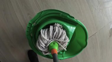 Pov paspası kova suyla yıkıyor. Temizlik ve ev işleri konsepti. Yakın plan.
