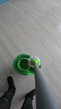 Temizlik için kova içinde paspas yıkama. POV, yakın plan.