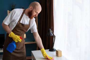 Temizlik hizmeti konsepti. Hijyen masası için şişe sakallı adam. Daha temiz bakteri temizleme ve temizlik. Boşluğu kopyala