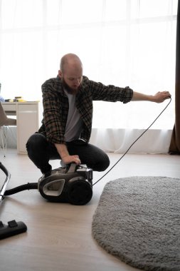 Evdeki elektrikli süpürge kablosu oturma odasının iç tarafında. Boşluğu kopyala