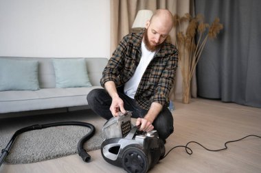 Sakallı adam ev yapımı elektrikli süpürge kutusu. Sık sık temizlik. Oda servisi, ev ve temizlik konsepti