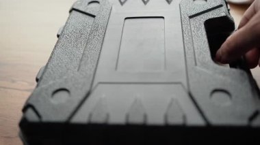 Bir zanaatkarın eli elektrikli matkapla bir kutuyu açar ve bir alet çıkarır. Yakın plan..