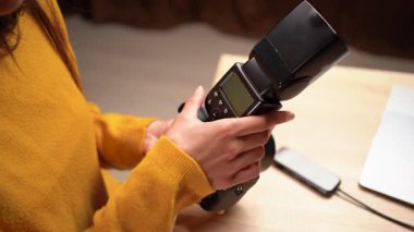 Fotoğraf çekimi, profesyonel ekipman ve iş akışı kavramının sonunda dış flaşları kameradan ayıran fotoğrafçının ellerine yakın çekim