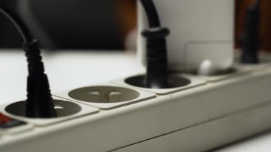 Erkek eli birden fazla prize elektrik prizi takmış. Elektrik teçhizatı ve elektrik enerjisi. Yakın plan.
