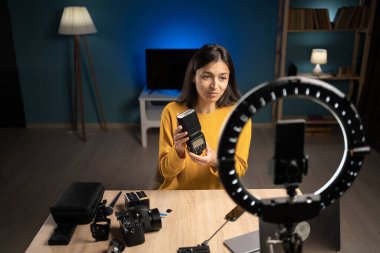 Kadın fotoğrafçı içerik yaratıcısı sosyal medya için akıllı telefonu kullanıyor, video blokluyor ve canlı yayın yapıyor. Nüfuzlu fotoğrafçı eğitim podcast 'i sunuyor. Kamera flaş ipuçları veriyor.