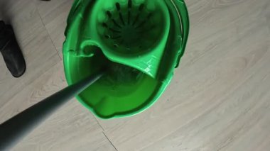 Yeşil kovada yıkanan paspas kabı. Ev işleri, temizlik ve ev işleri konsepti. Yakın plan.